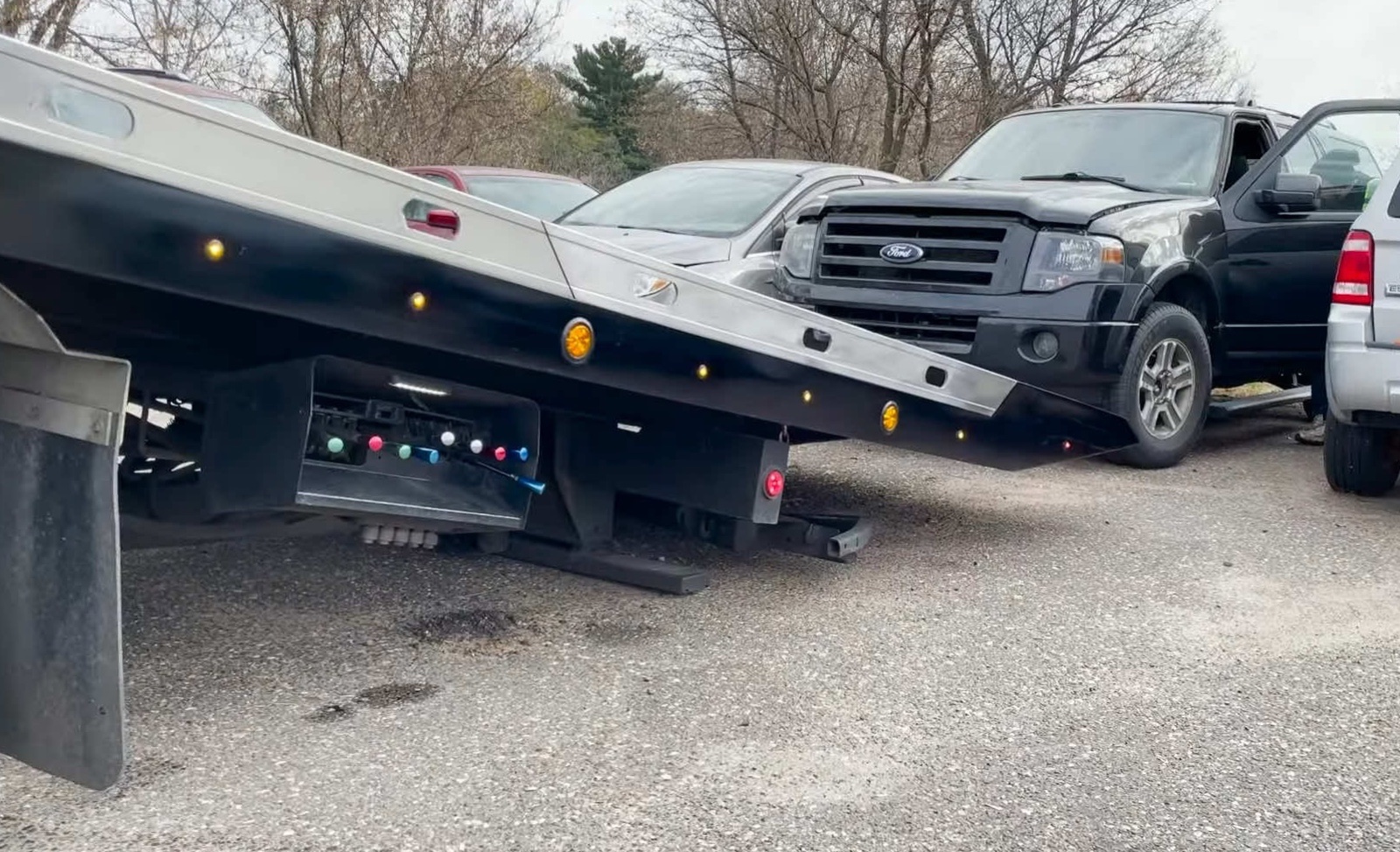 Flatbed collecting an old vehicle for scrap-car removal